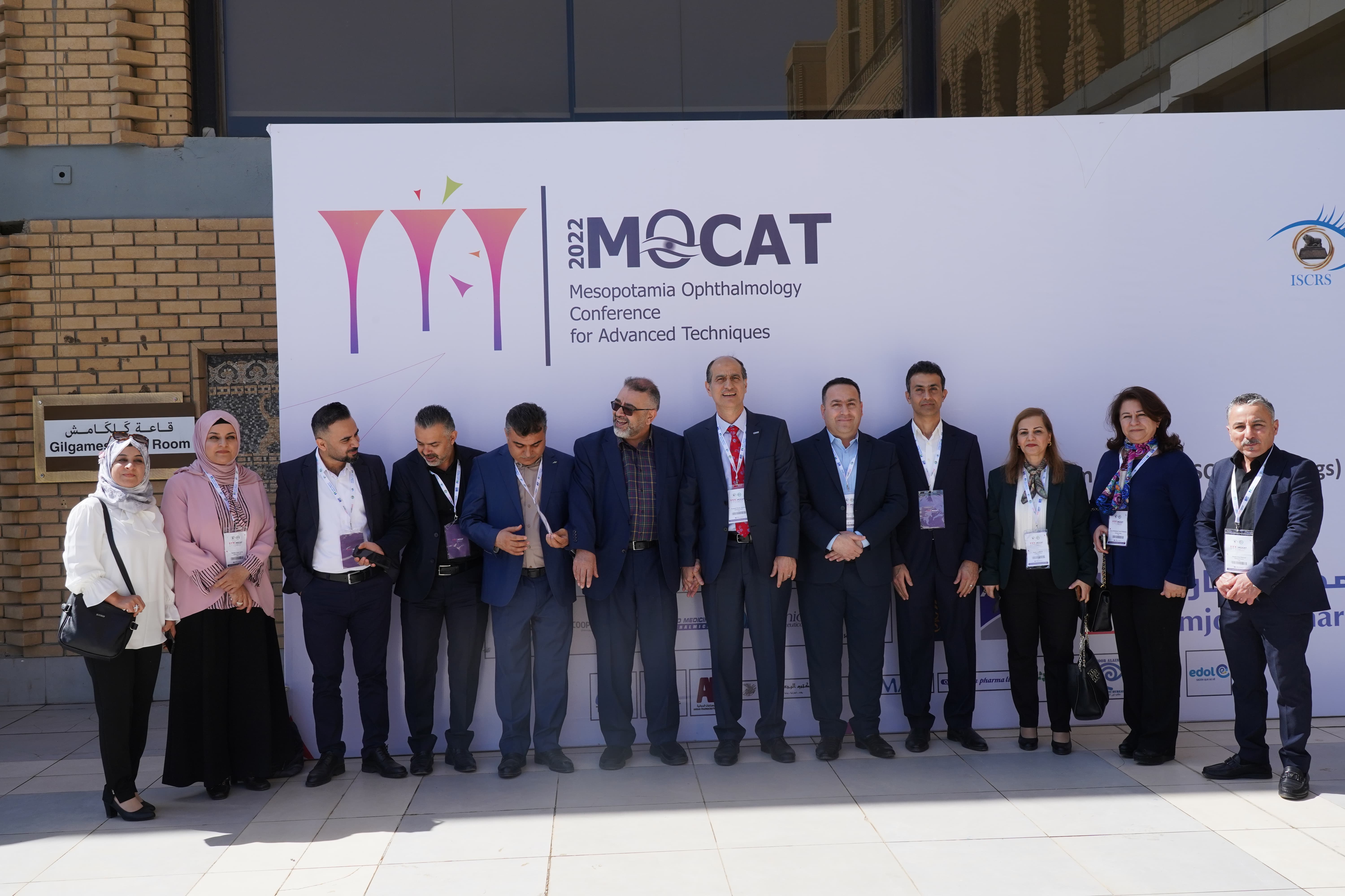Group photo of MOCAT 1 participants in front of conference banner