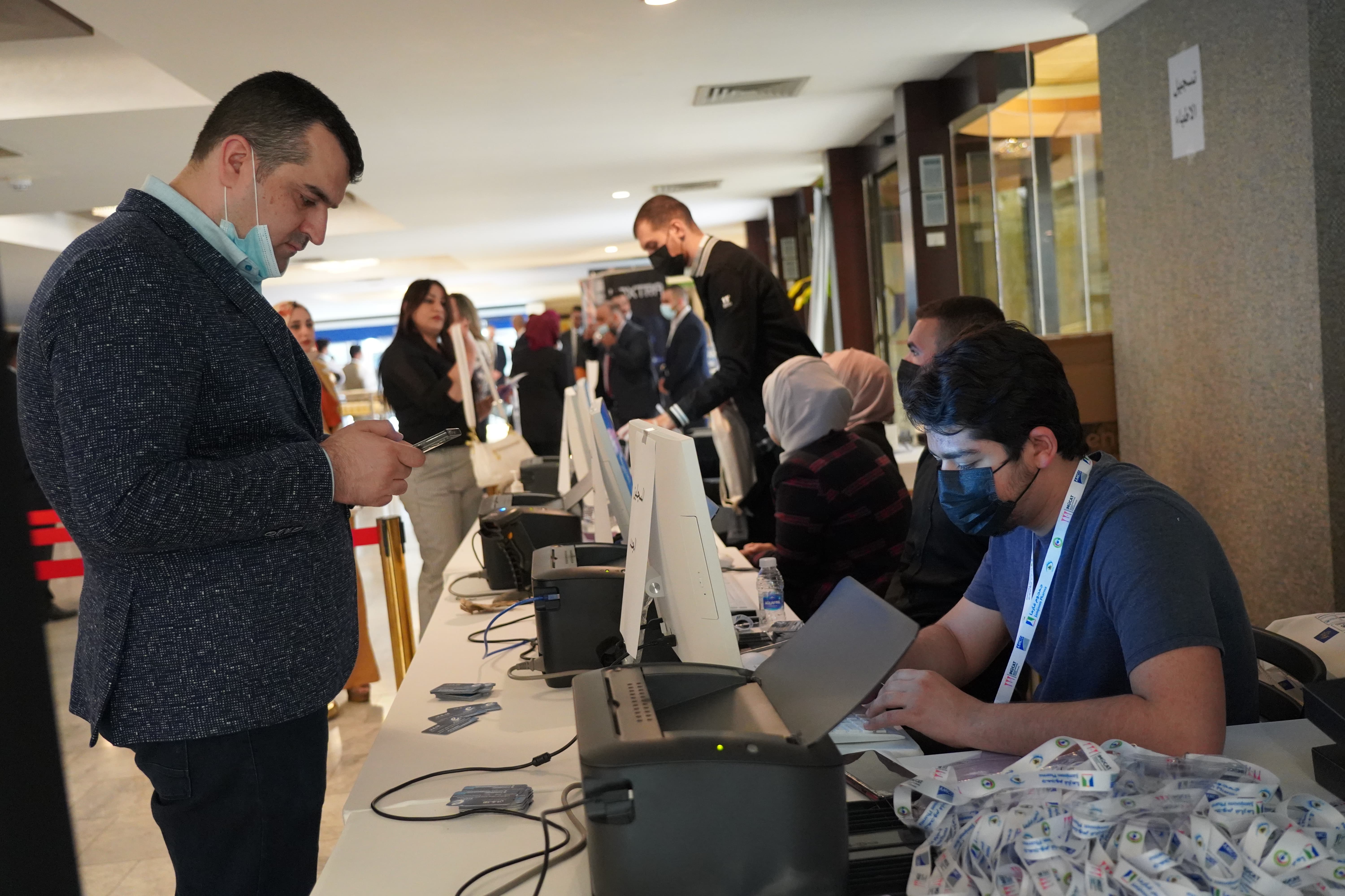 Registration and check-in area with staff assisting attendees